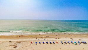 A beach with umbrellas and people.