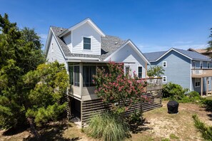 A two-story house with a covered porch and a fenced backyard.