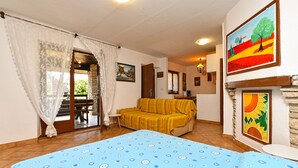 Ein Zimmer mit einem Bett, einer Couch, einem Esstisch und einem Kamin.