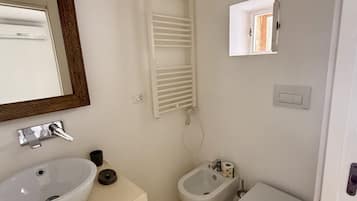 Chuveiro, bidê, toalhas de banho