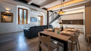 Un intérieur moderne comprenant un coin repas, un canapé, un escalier et une cuisine.
