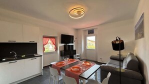 Een moderne keuken met een eethoek, een bank en een televisie.