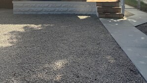 A covered porch with two chairs and a small table, a stone facade, and a clear blue sky. - Turtle's Nest, 3 BR+3BA, dog friendly, Conch Cottage in Midtown Key West (Key West)