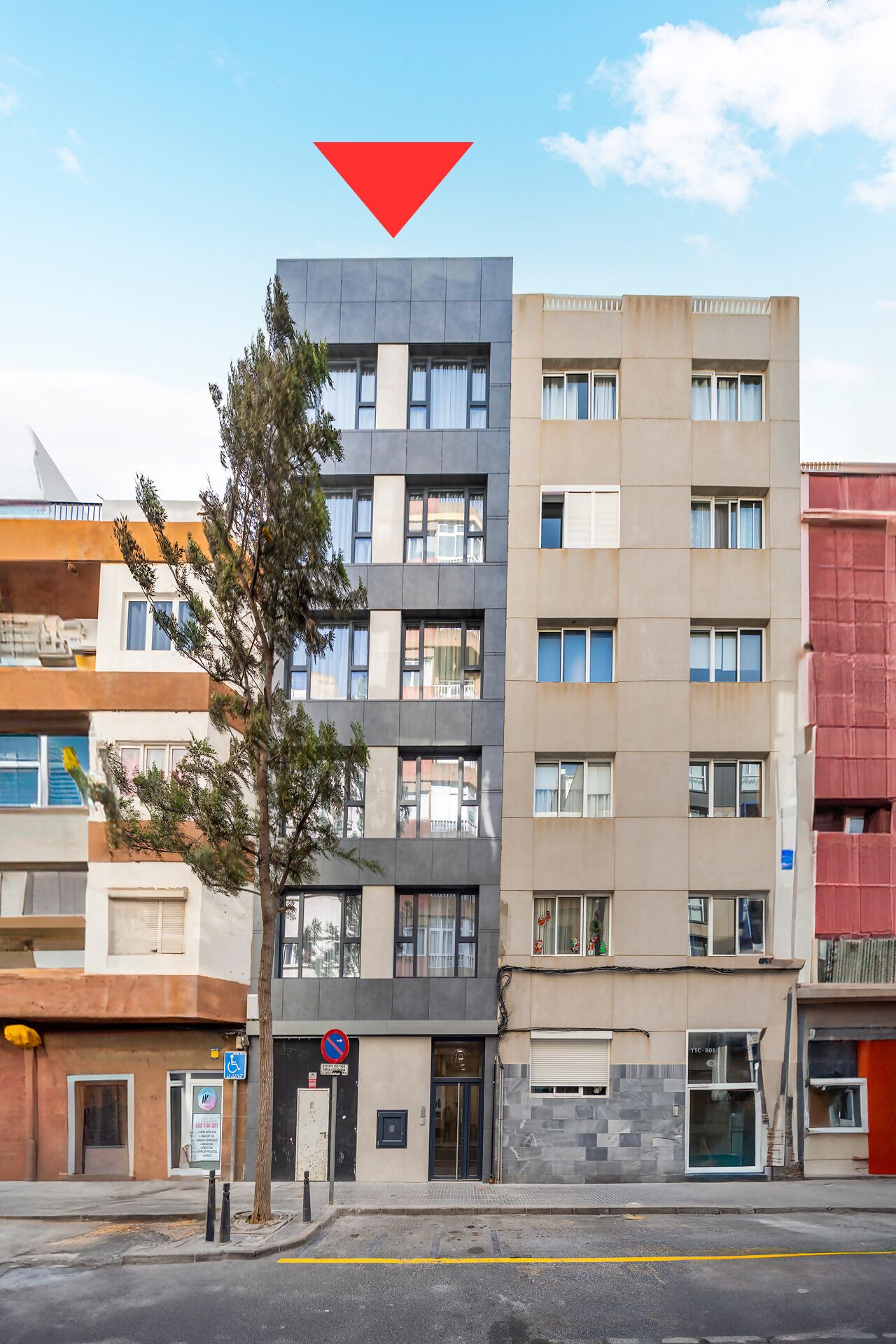 A multi-story building with a modern architectural design, featuring a mix of balconies and windows.