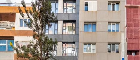 A multi-story building with a modern architectural design, featuring a mix of balconies and windows.