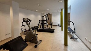 A gym with cardio machines, weightlifting equipment, and a bench. - The Wave Musso - Larihome A87 (Musso)