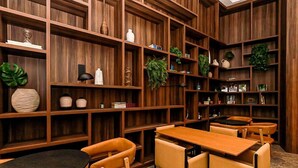 A room with wooden bookshelves, a round table, and four chairs.