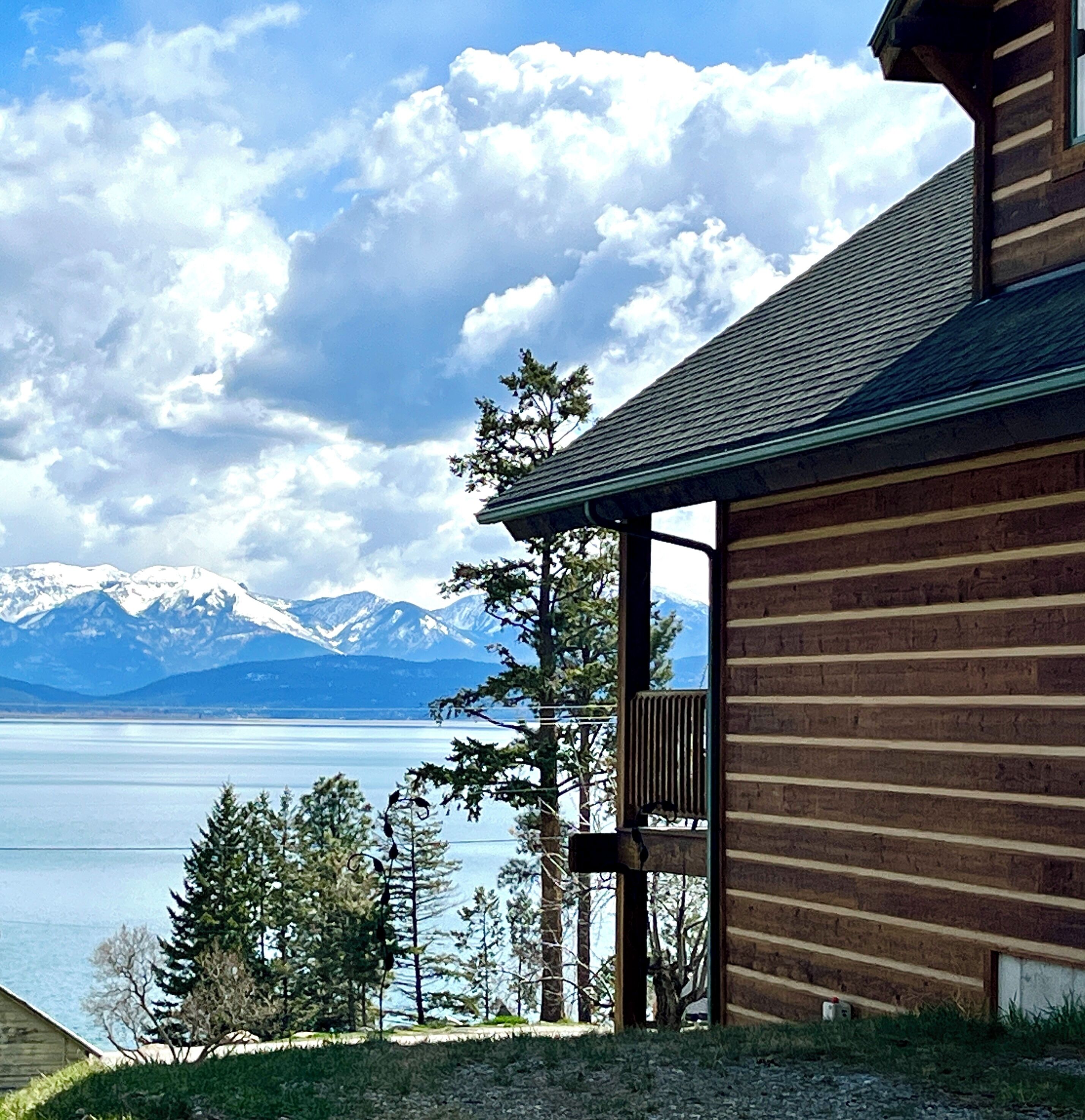 Eine Holzhütte mit einem Balkon mit Blick auf einen See und Berge.