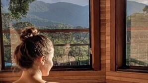 A person sitting in a bathtub with a view of mountains through large windows. - Flores da Mantiqueira (Monte Verde)