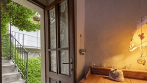 A wooden door with glass panels, a staircase leading outside, and a wooden cabinet with a mirror and glasses.