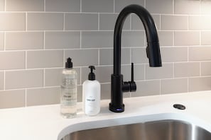 Eine Küchenspüle mit modernem Wasserhahn und Seifenspendern.