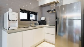 A modern kitchen with a stainless steel refrigerator, a coffee machine, and a water dispenser. - Gyeongju Ain Kids Pool Villa (Gyeongju)