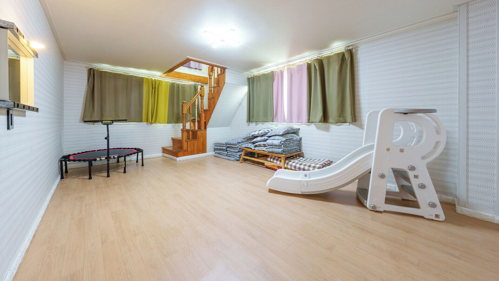A children's play area with a trampoline, slide, and climbing structure.