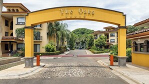 En portindgang til et hotel med en gul buegang med påskriften 'The Oaks'.