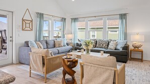A living room with two sofas, a coffee table, and a side table with a lamp. - Steps to the Beach l Pool l Tiki Bar & Pet-Friendly (Crystal Beach)