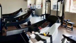 Un gimnasio con cintas de correr, máquinas de pesas y un ventilador.