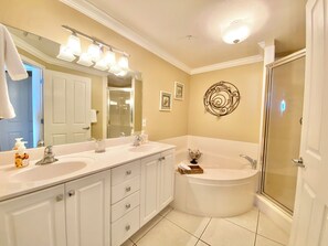 Une salle de bain moderne avec deux lavabos, un grand miroir, une douche et un élément décoratif mural.
