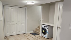 Une buanderie équipée d’un lave-linge, d’un sèche-linge et d’un escalier menant à un autre niveau.