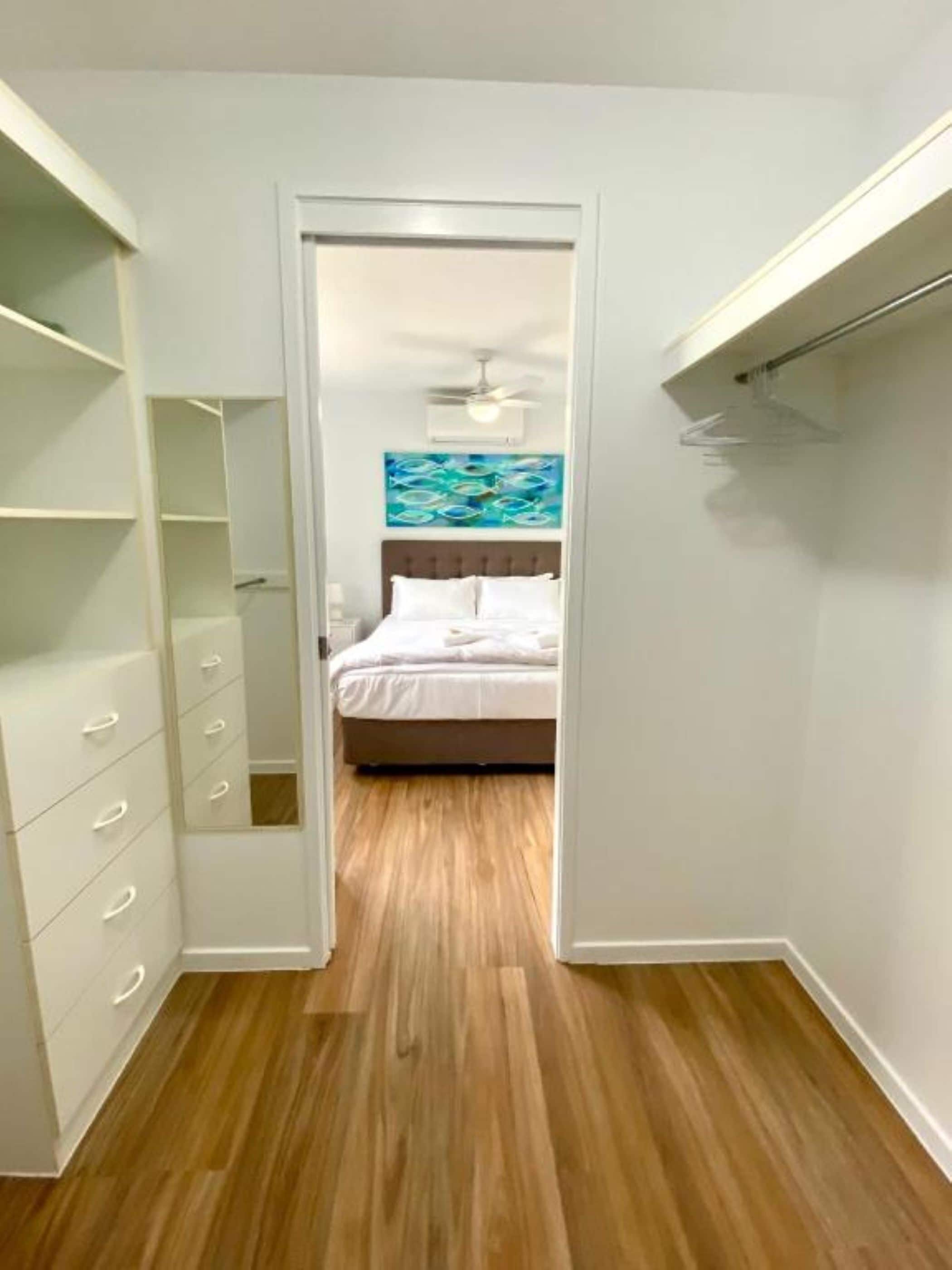 Ein Schlafzimmer mit einem Bett, einem Deckenventilator und einem Bild von Fischen an der Wand.
