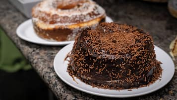 A chocolate cake with chocolate sprinkles on a white plate.