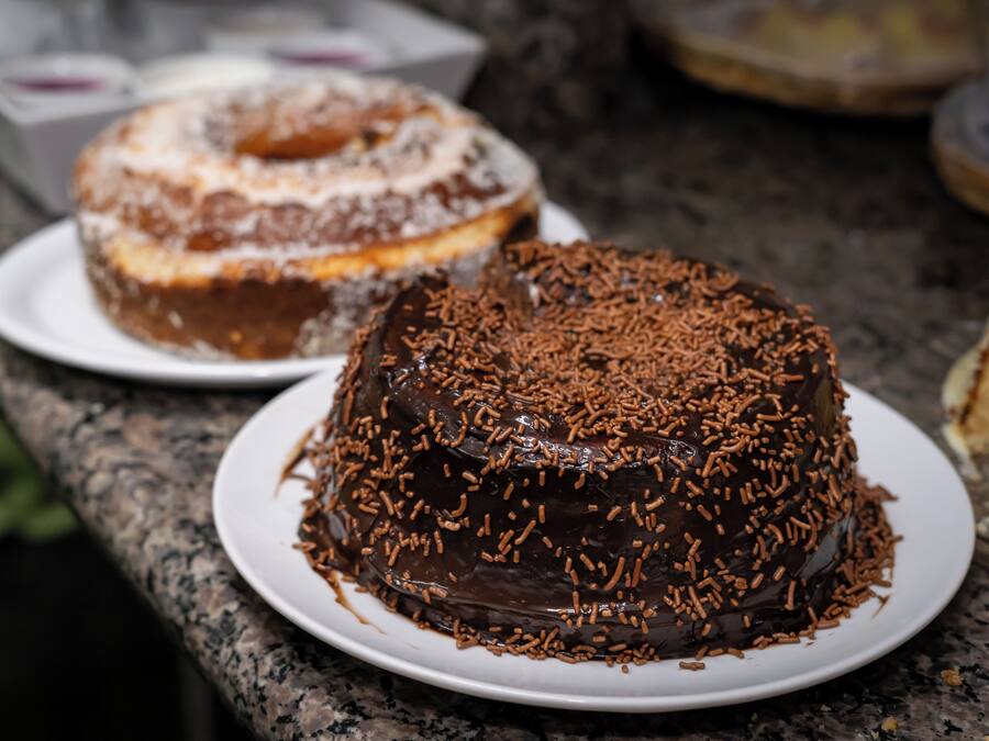 A chocolate cake with chocolate sprinkles on a white plate.