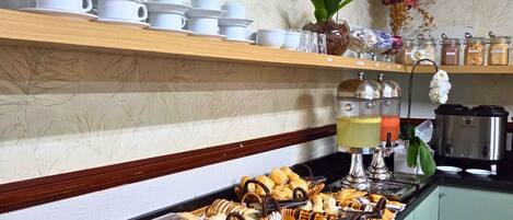 Un bufé con diferentes opciones de comida, como pasteles, sándwiches y una gran variedad de postres.