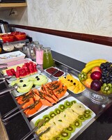 Un bufé con diversas frutas y bebidas.