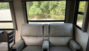 Relax in comfort with a two-seater sofa and enjoy the view of the surrounding woods from the window.
