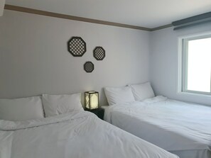 A hotel room with two beds, a window, and decorative wall art. - Liebe stay (Busan)