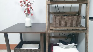 A wooden shelf unit with woven baskets and a white vase with red flowers. - Liebe stay (Busan)