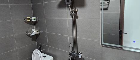 A modern bathroom with a toilet, bidet, shower, and sink.