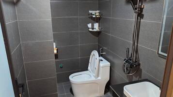 Un baño moderno con inodoro, lavamanos y ducha.