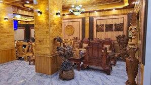 A room with wooden paneling, a chandelier, and ornate furniture. - New Highland Hotel (Mu Cang Chai)
