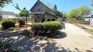A residential house with a covered patio, a driveway, and a fenced yard. - 3-Bedroom House Close to Pacific University (Forest Grove)