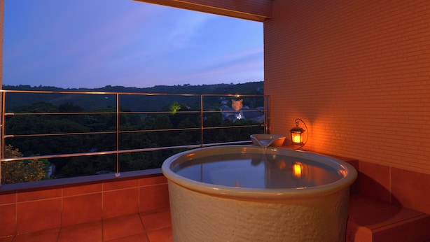 A bathroom with a bathtub, a window, and a view of a forest. - kokopellihouseizukogen (Ito)