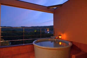 A bathroom with a bathtub, a window, and a view of a forest. - kokopellihouseizukogen (Ito)