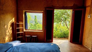 A room with a bed, a window, a ladder, and a view of greenery outside. - Homestay Khám Phá Y Tý (Y Ty)