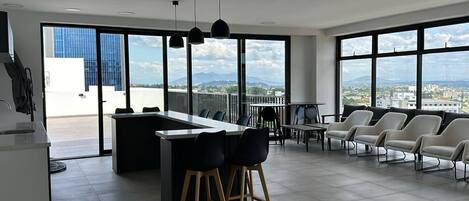 Una cocina moderna con barra, ventanas amplias y vistas a la ciudad.