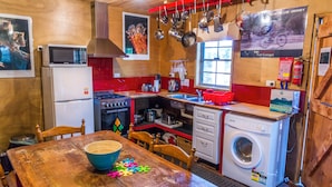 Une cuisine compacte équipée d’un four à micro-ondes, d’une cuisinière, d’un évier et d’un lave-linge.