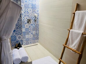 A bathroom with a shower, a wooden ladder, and a patterned wall. - Hôtel Boma (Dakar)