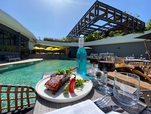 A dining table with a plate of food, a bottle of water, and glasses. - Hôtel Boma (Dakar)