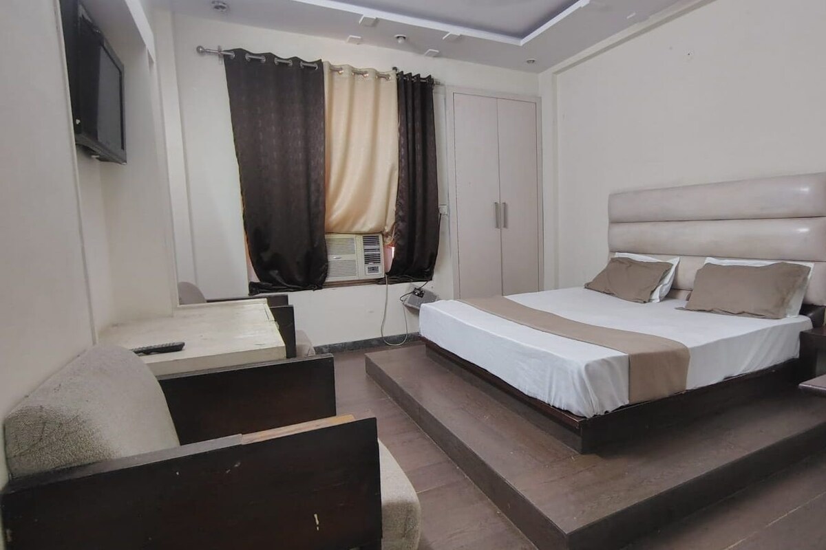 A hotel room with a bed, a desk, and a television.