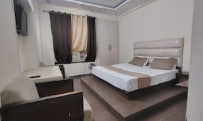 Una camera d'albergo con un letto, una scrivania e un televisore.