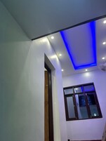 Una habitación con techo inclinado, iluminación empotrada y ventana con vistas al exterior.