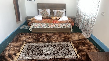 Un dormitorio con una cama, una alfombra estampada y un cabecero de madera.