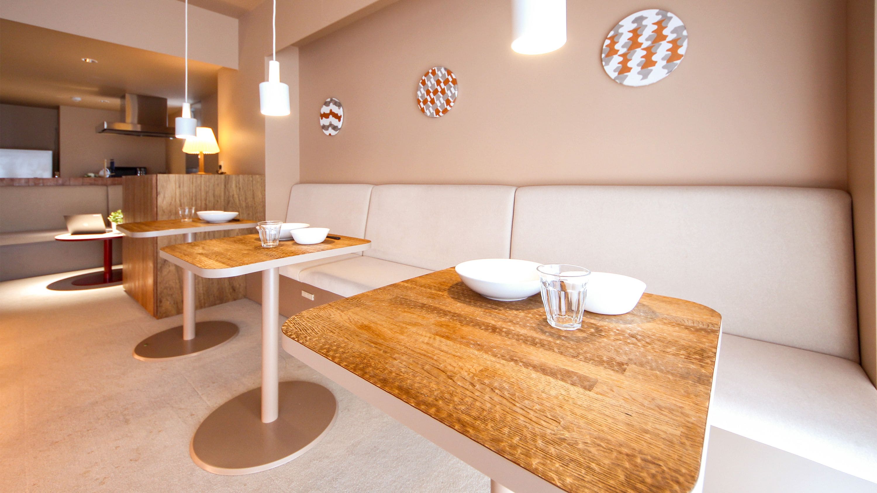 A modern dining area with wooden tables and white seating.