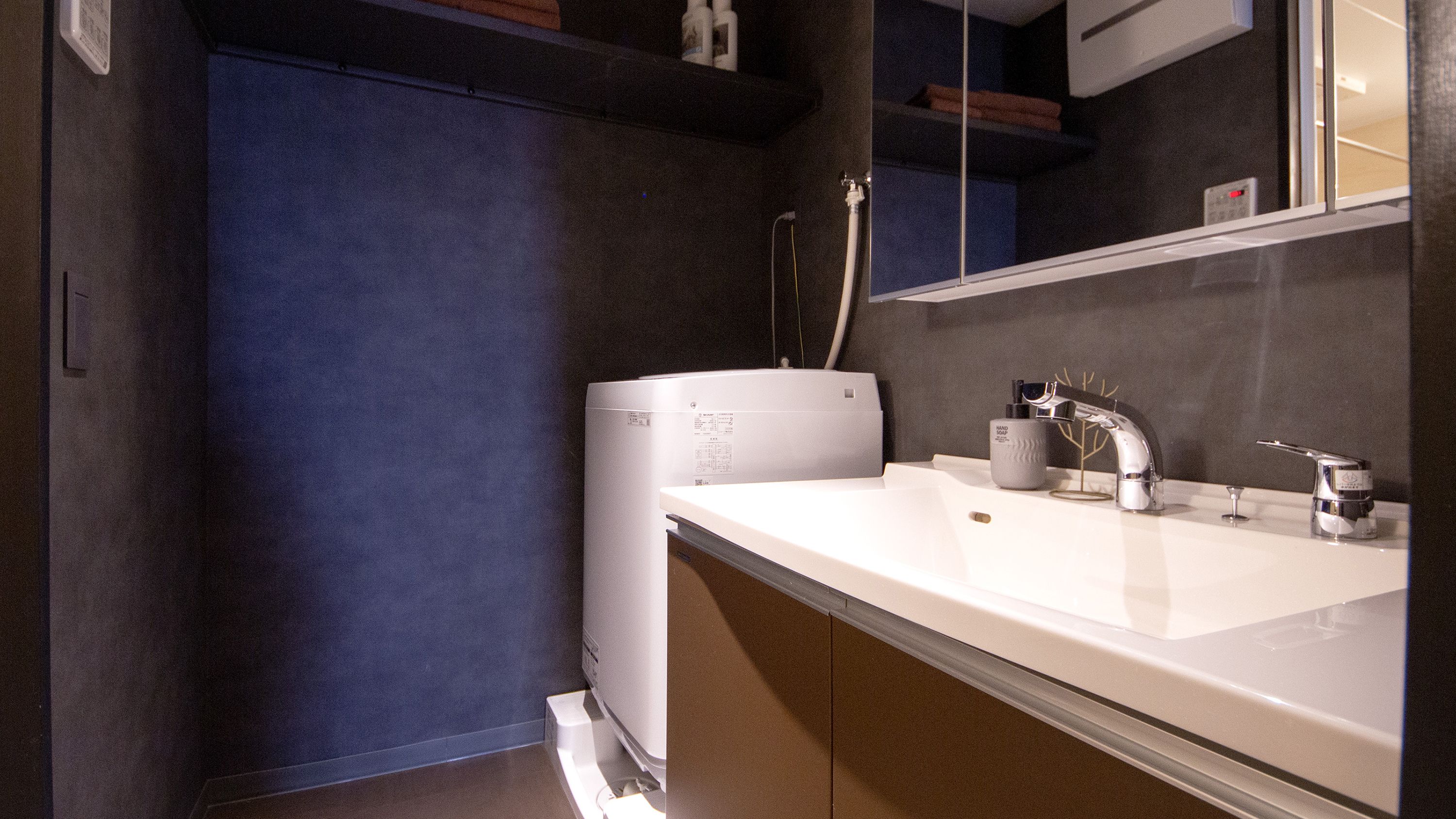 A modern bathroom with a white sink, a mirror, and a toilet.
