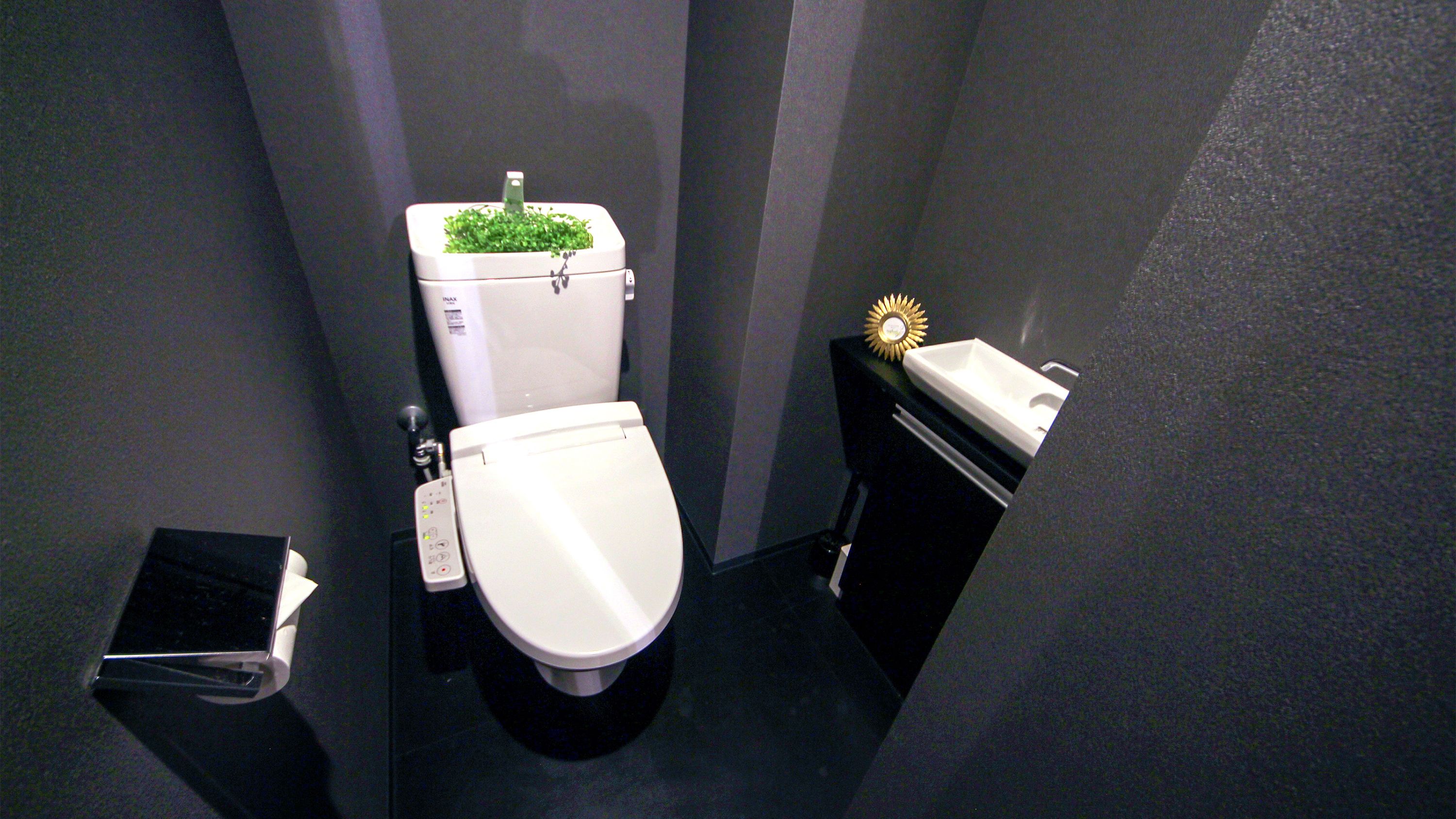 A compact bathroom with a toilet, bidet, and a small sink.