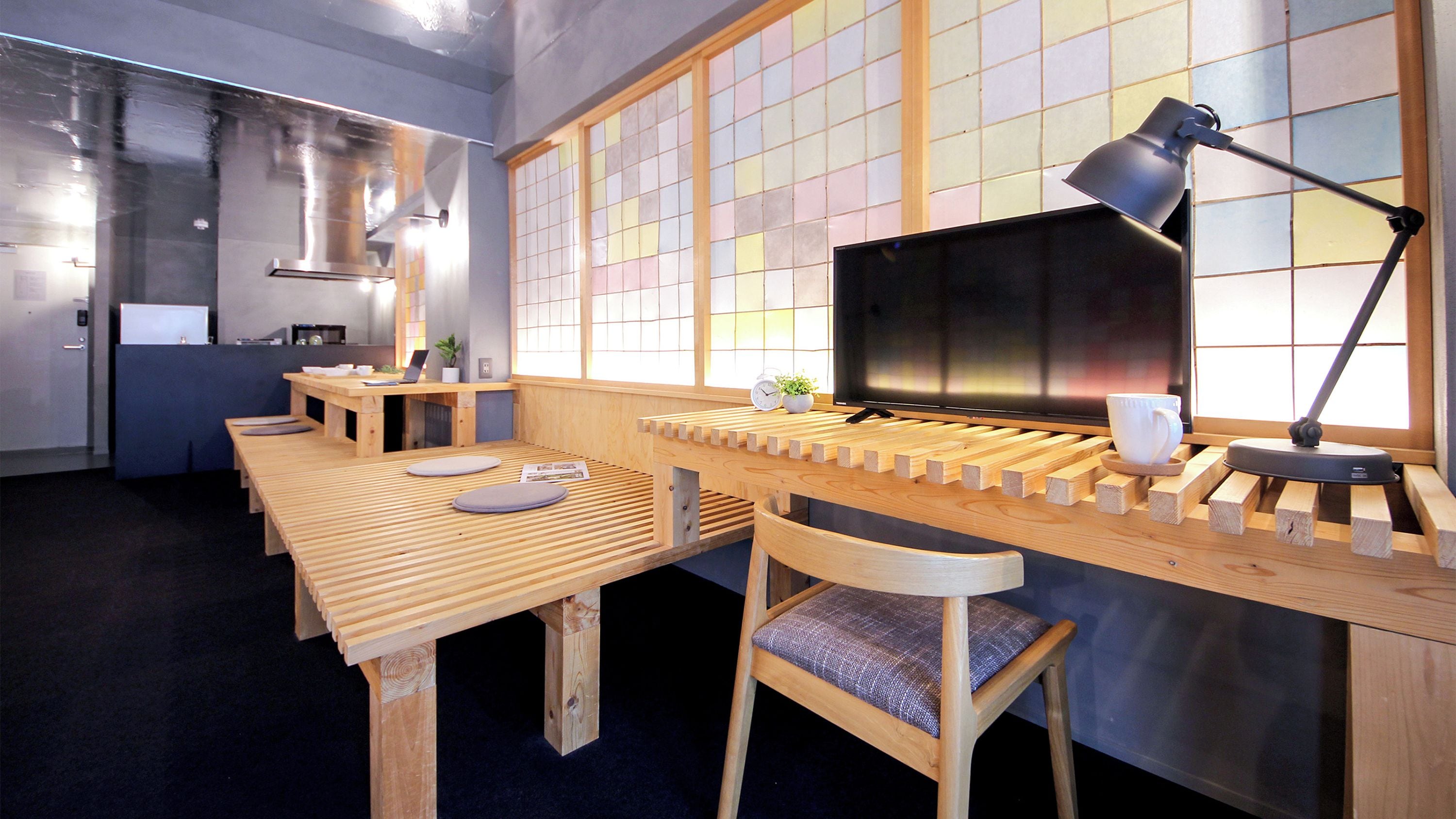 A modern kitchen with wooden furniture, a laptop, and a coffee cup.