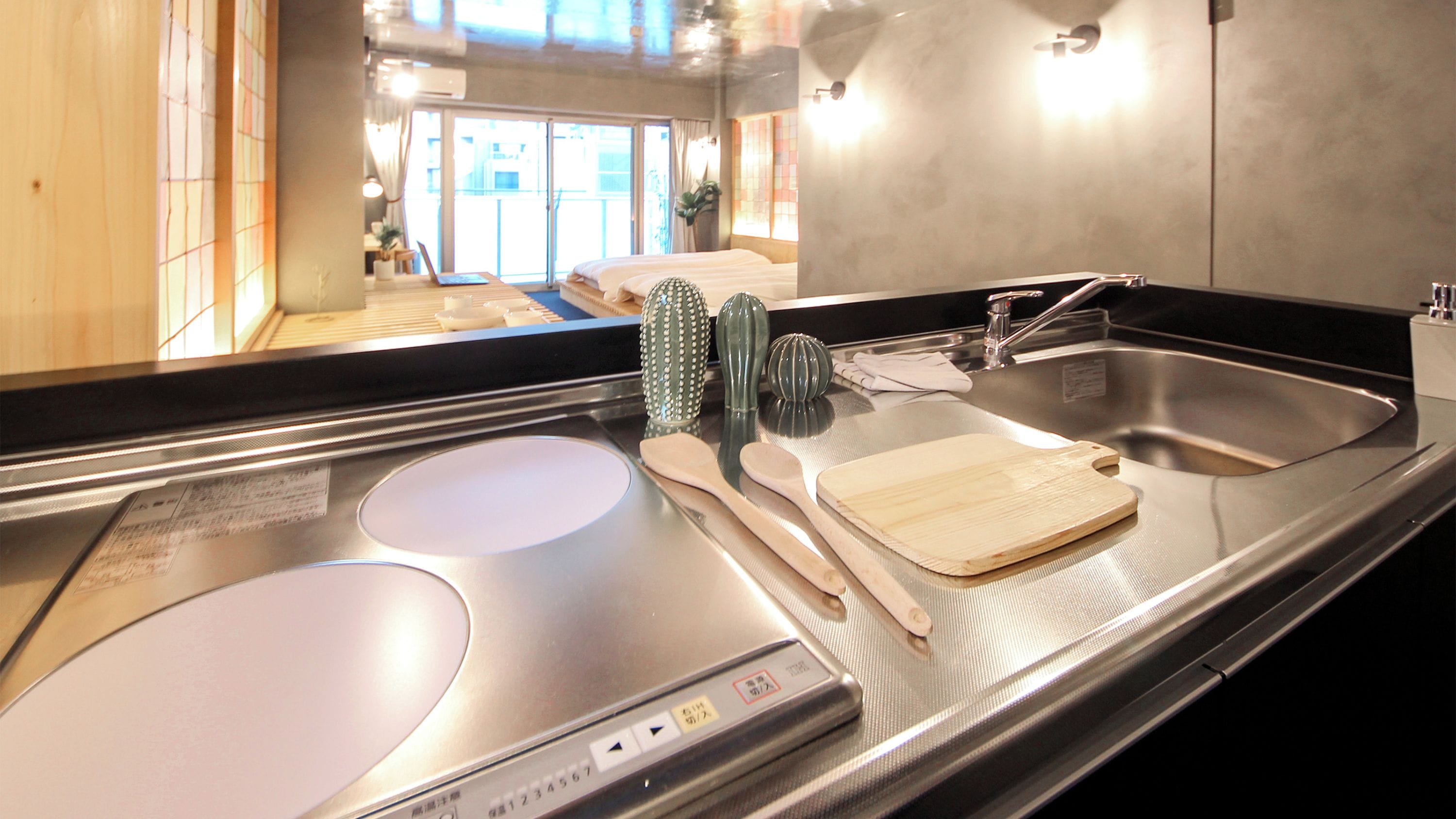 A kitchen with a stainless steel countertop, a sink, and a stove.